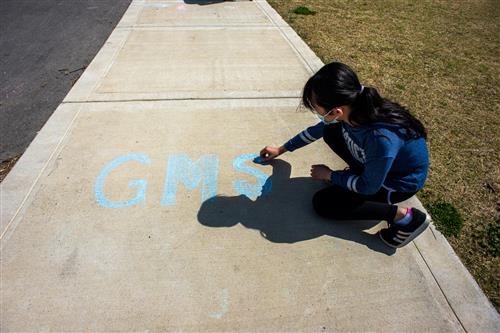 student drawing on sidewalk