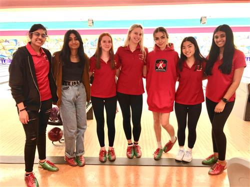 girls bowling team posing at the lanes