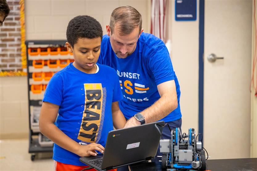SMS students build robots with teacher.