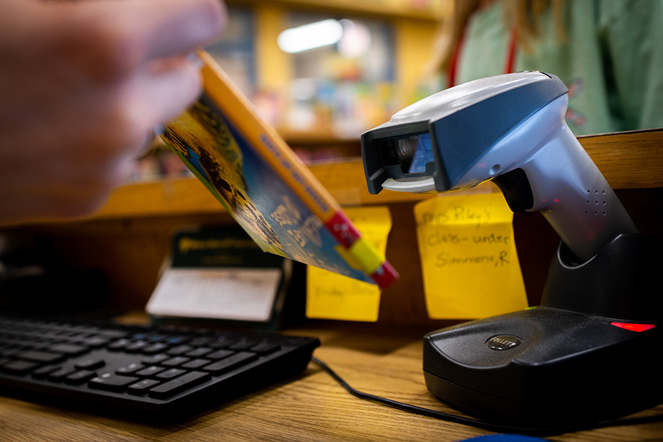 Scanner in library, scanning a barcode on a book.