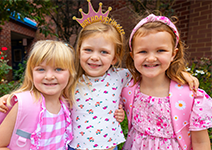  three girls smiling in pink shirts