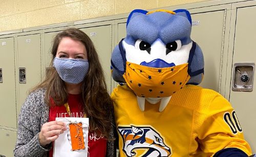 Mrs. Hallbright, a TSMS Counselor is greeted by the Pred's Mascot, Gnash.