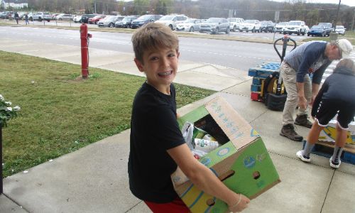 A student council member loads boxes of food from their Fall Canned Food Drive into the truck.