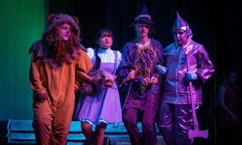 The cast of The Wizard of Oz perform onstage.