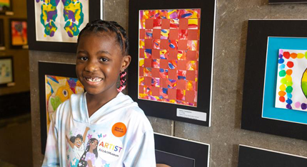 Student standing by her artwork at the Frist Art Showcase