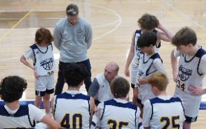 Boys team in huddle with coach
