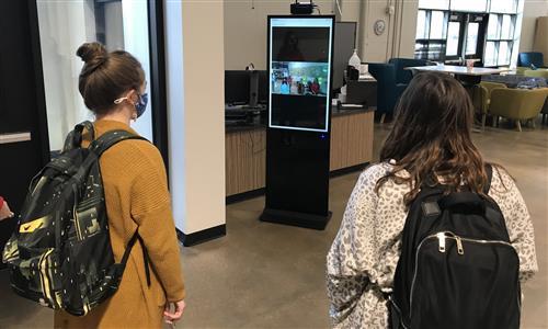 Students look at a kiosk 