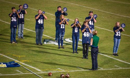 band members play on a football field 