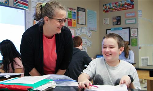 Student laughs with teacher 