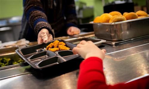 Student reaches for lunch tray