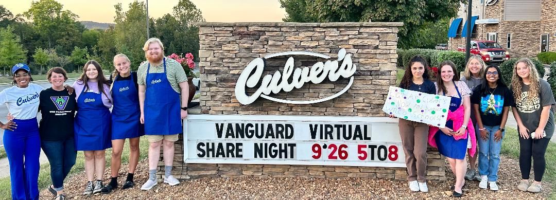 students and culvers staff in front of sign