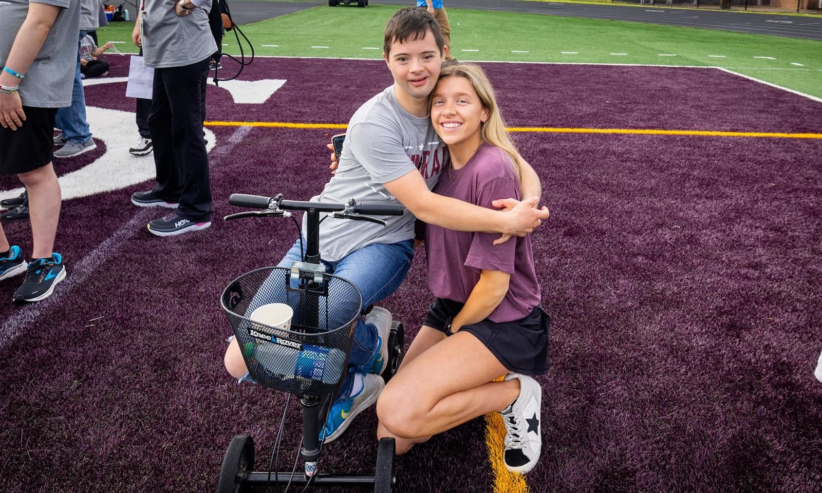 Two students hug on the football field