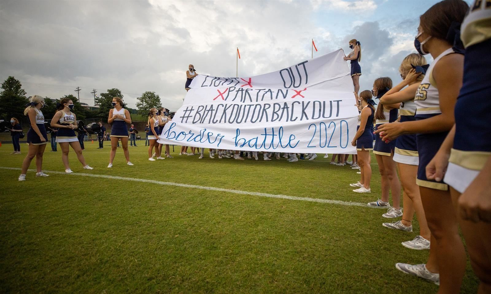 Cheerleaders hold up sign 