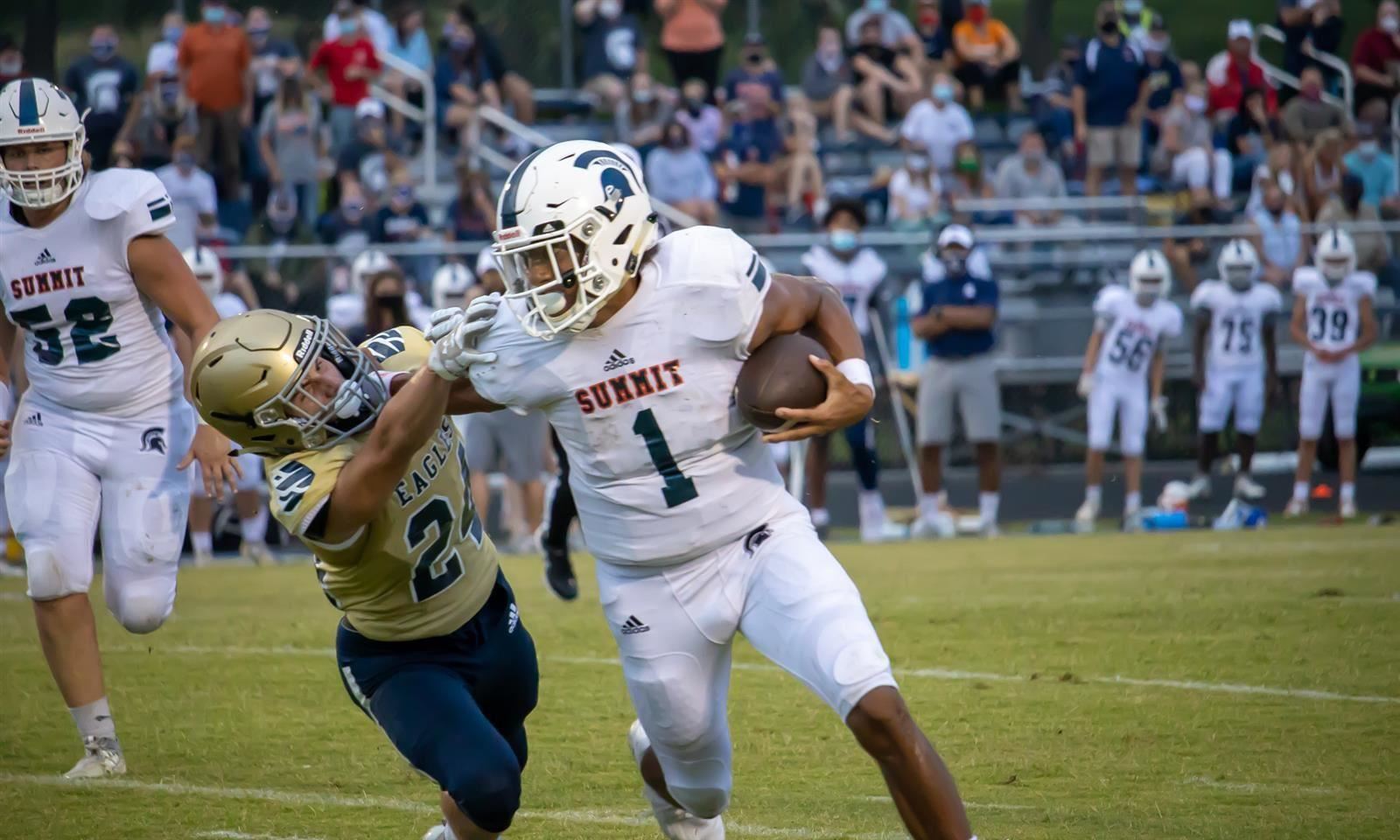 Football player blocks tackle 