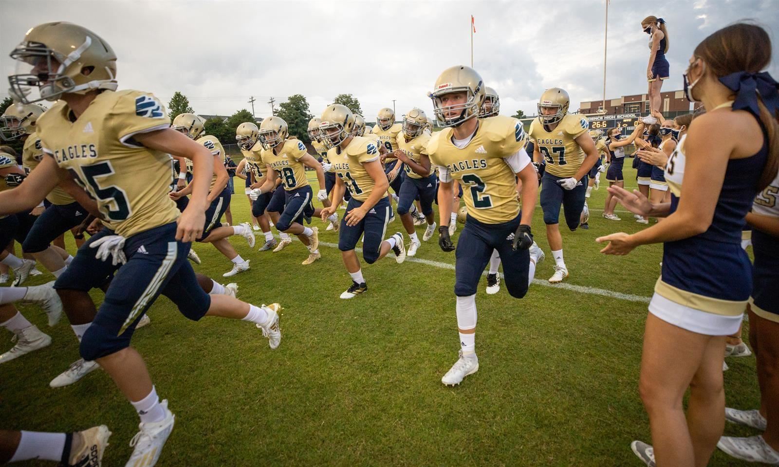 football players run onto field 