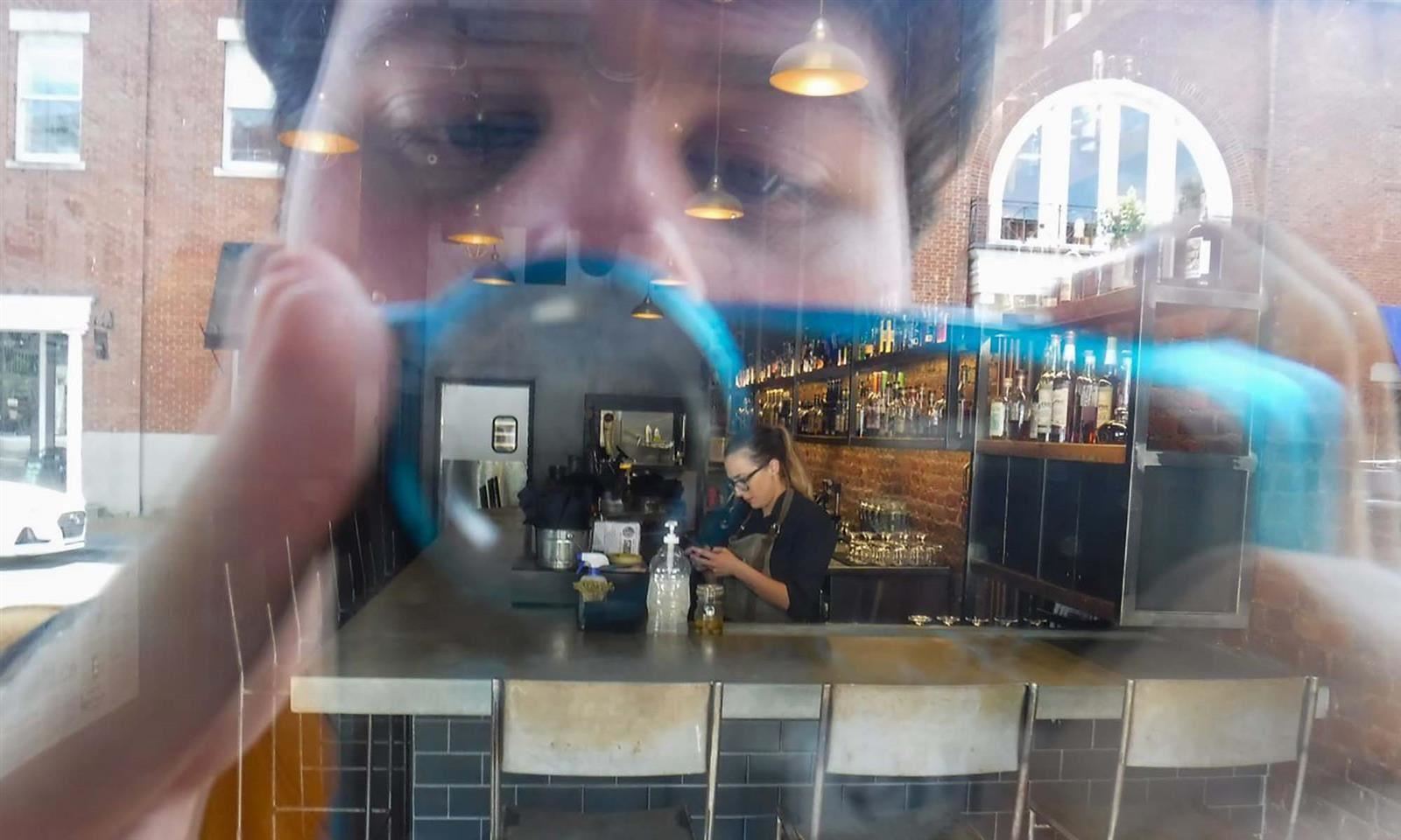 Reflection of boy taking picture 