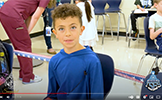  boy in blue shirt sitting in chair