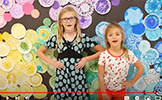 two girls in front of colorful dot wall 