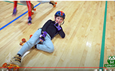  boy laying on gym floor and helmet and roller skates