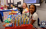  students sitting at tables with juice boxes