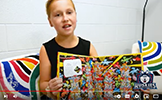  girl holding up a where's waldo book