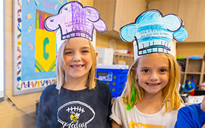 two girls smiling in hats 