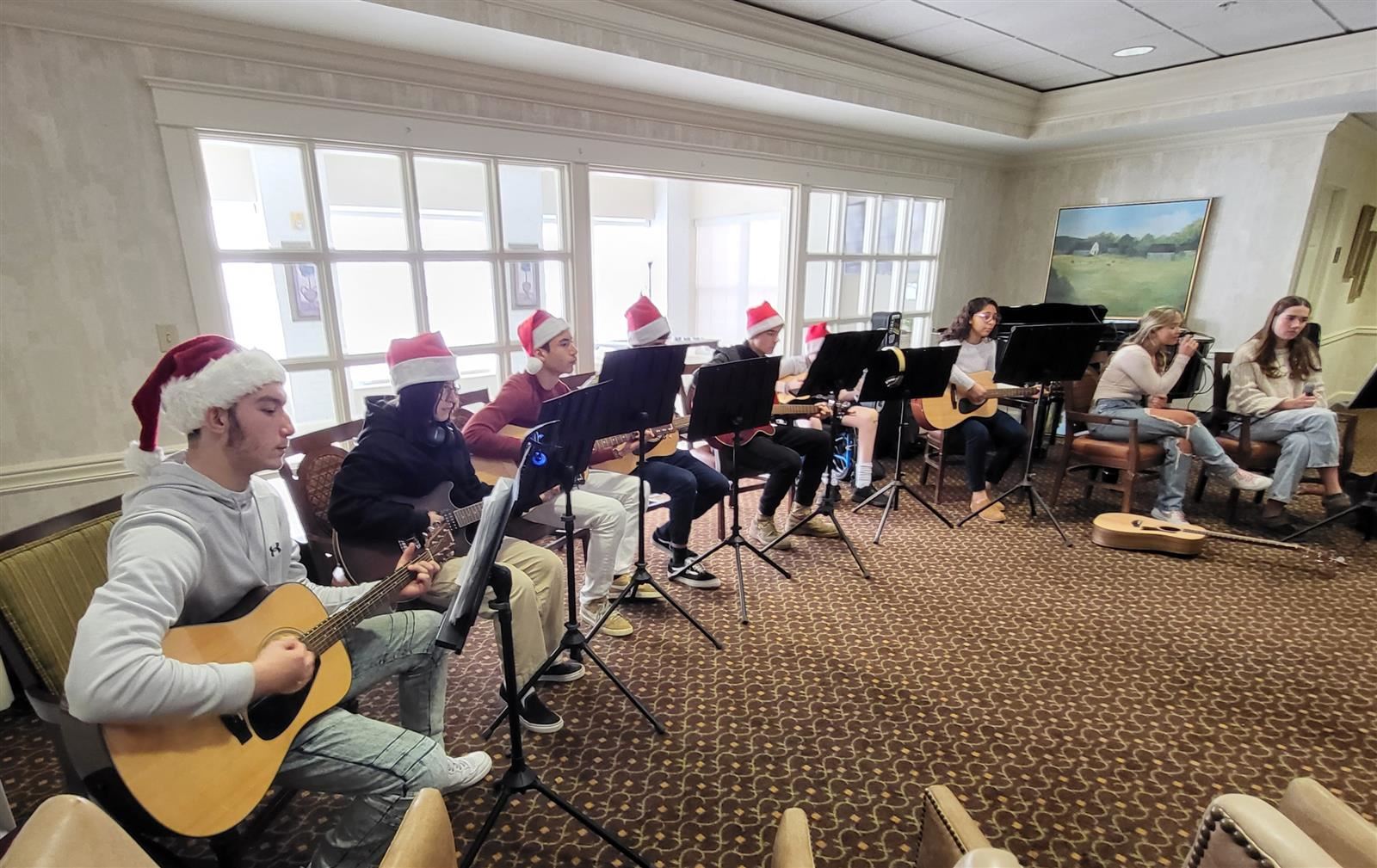  Students playing guitar and wearing santa hats