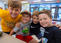  four boys smiling in the cafeteria