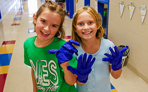 two girls with blue rubber gloves 