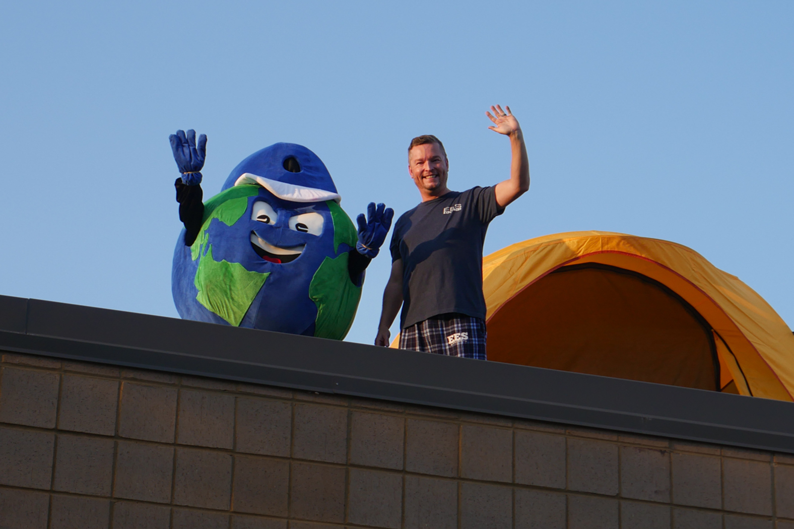 principal and mascot waving from the roof