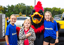 three girls with cardinal mascot 