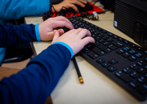  hands typing on computer