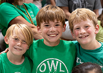  three boys smiling in green shirts