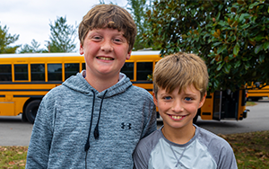  Two male students outside by the school bus