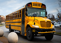  Yellow school bus parked outside a school building.