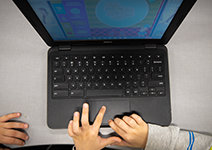  A hand working on a laptop computer.