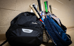  Backpacks with tennis rackets on the floor in a hall