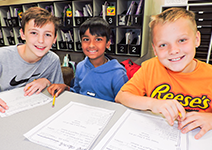  three boys at desks