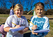  two students writing in journals