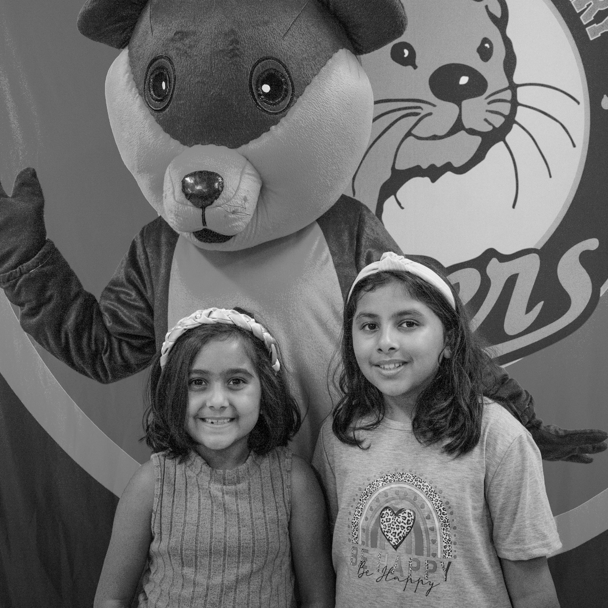 two girl students smiling with the Otter mascot