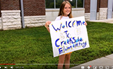  girl holding a welcome to creekside sign