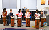  students playing bongo drums