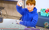  boy holding up ozobot robot