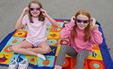  two girls in pink shirts with eclipse glasses on