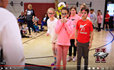  students in pink standing in a line in gym