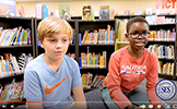2 boys sitting in the library 