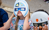  students wearing paper plate and eclipse glasses