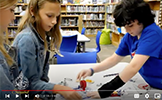  students with robot at table