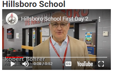  Male Principal talking in the school lobby.