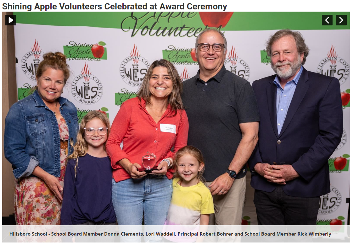  Two women, two children and two men smiling with apple award.